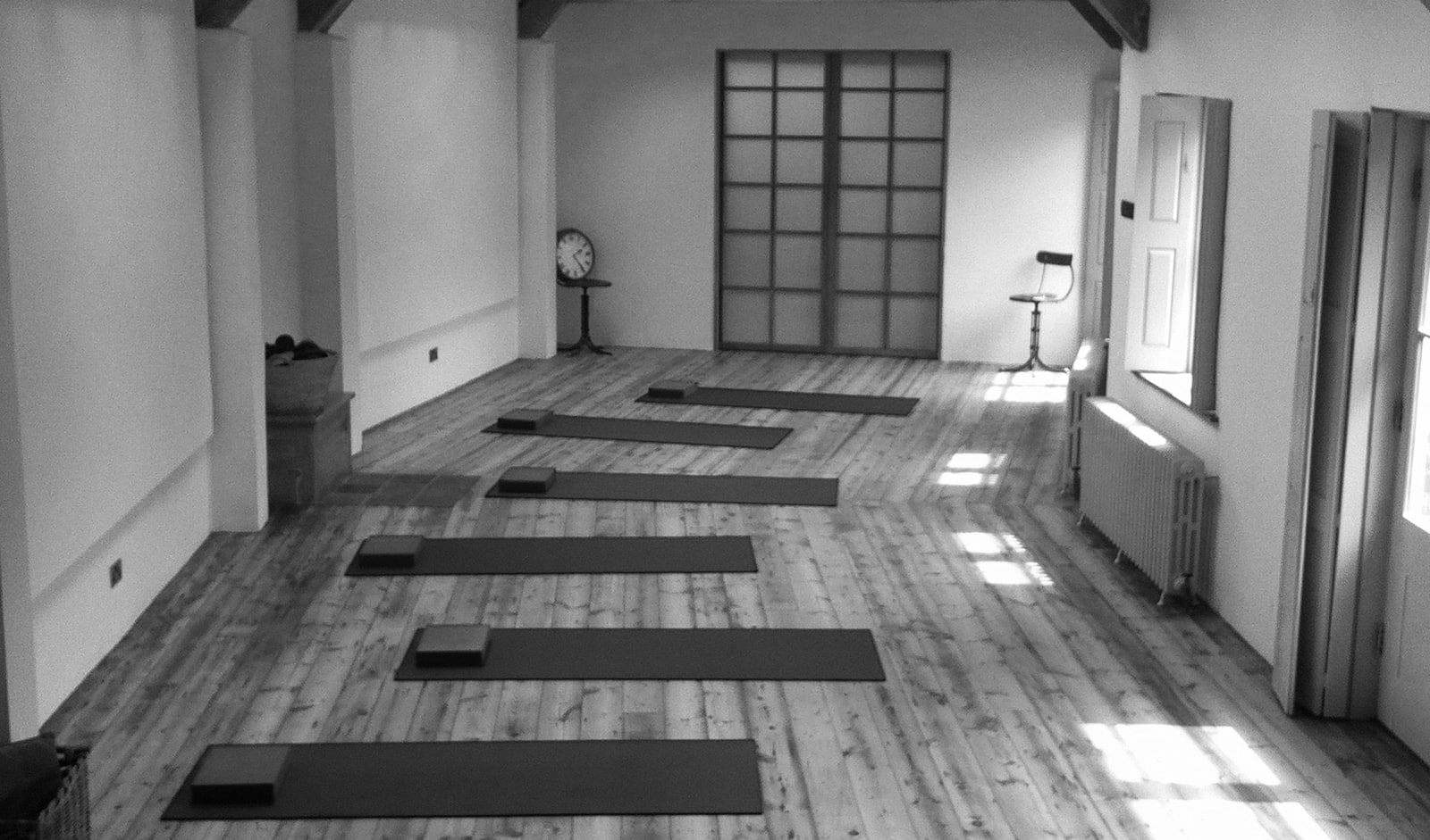 The North Barn studio: six mats laid on the boards, a shoji screen, a clock and side light